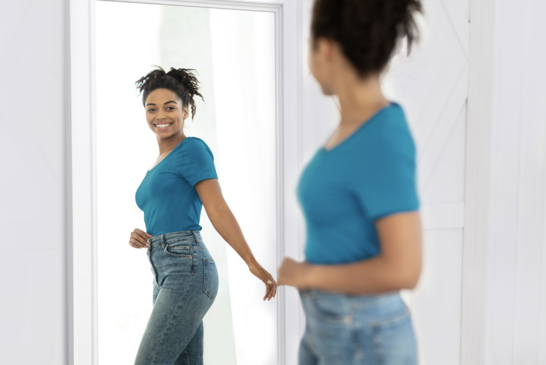 Woman fits into her favorite jeans, showcasing power of body composition and fat-to-muscle ratio vs. solely focusing on weight.